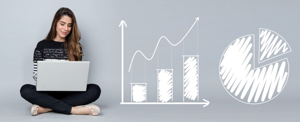 A woman sits cross-legged with her laptop beside two graphics of charts.