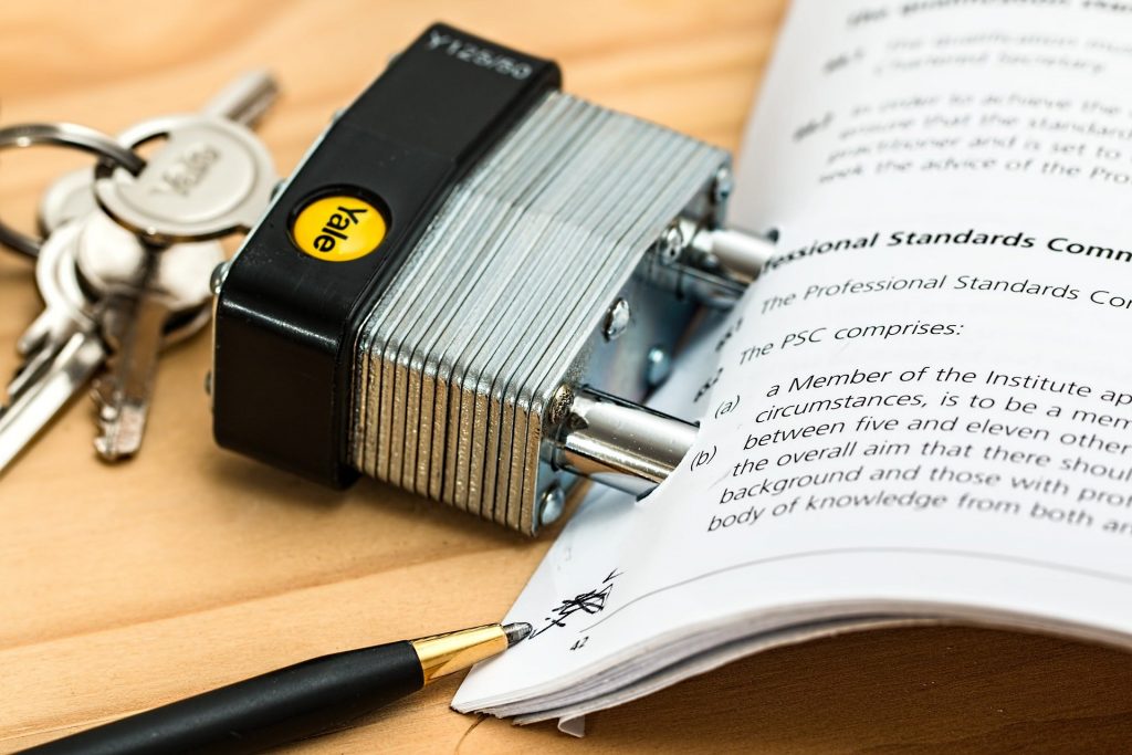 A lock holding several pieces of paper together to symbolize a contract.