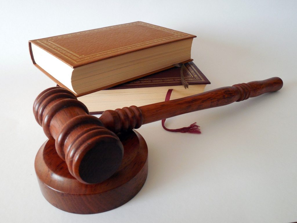 A judge's gavel resting beside a law textbook.