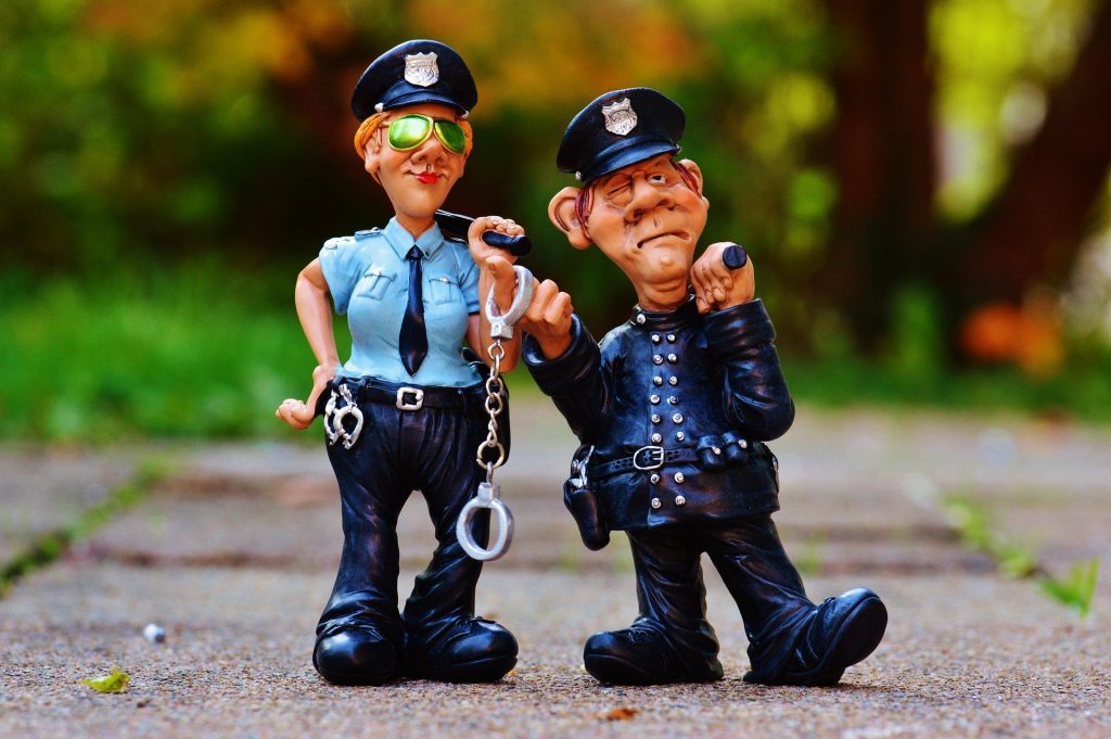 Police officer figurines standing on the pavement.