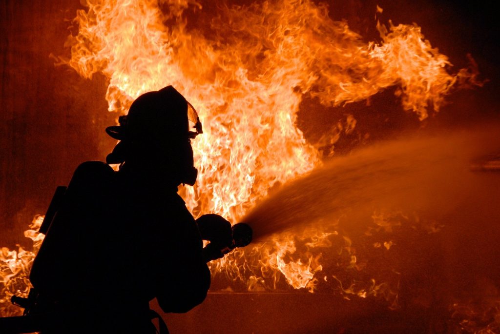 A firefighter aiming a hose at a blaze.