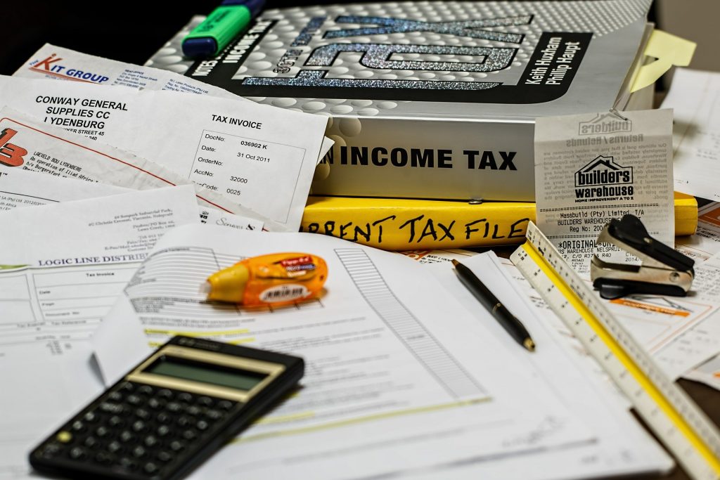 A calculator resting near books and other accounting tools.