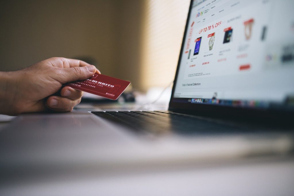 A man holding a credit card while online shopping.