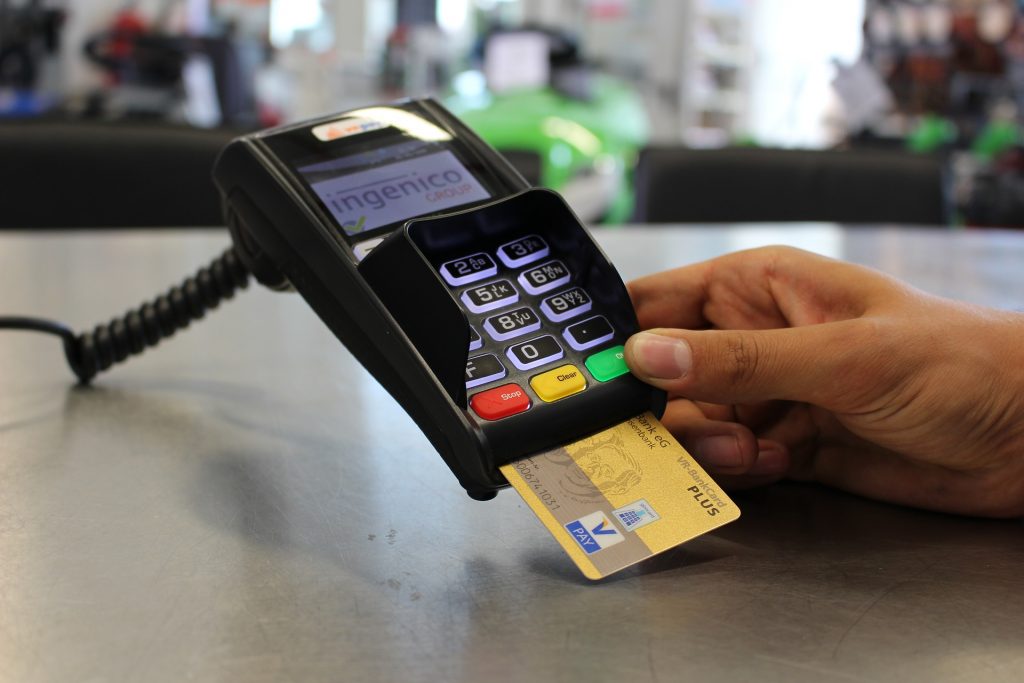 A golden credit card inserted into a payment machine.