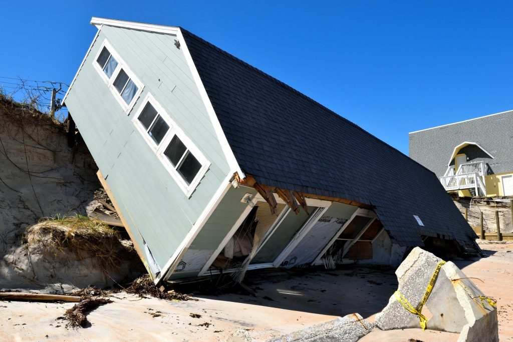 A house laying on its side after a landslide.